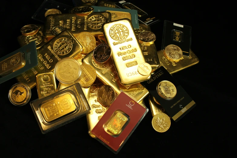 a pile of gold bars, coins and stamps