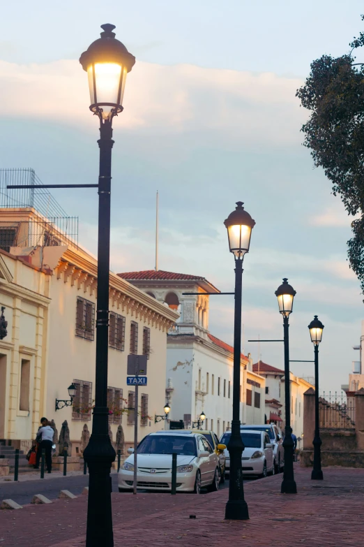 several parked cars and street lights on a city street