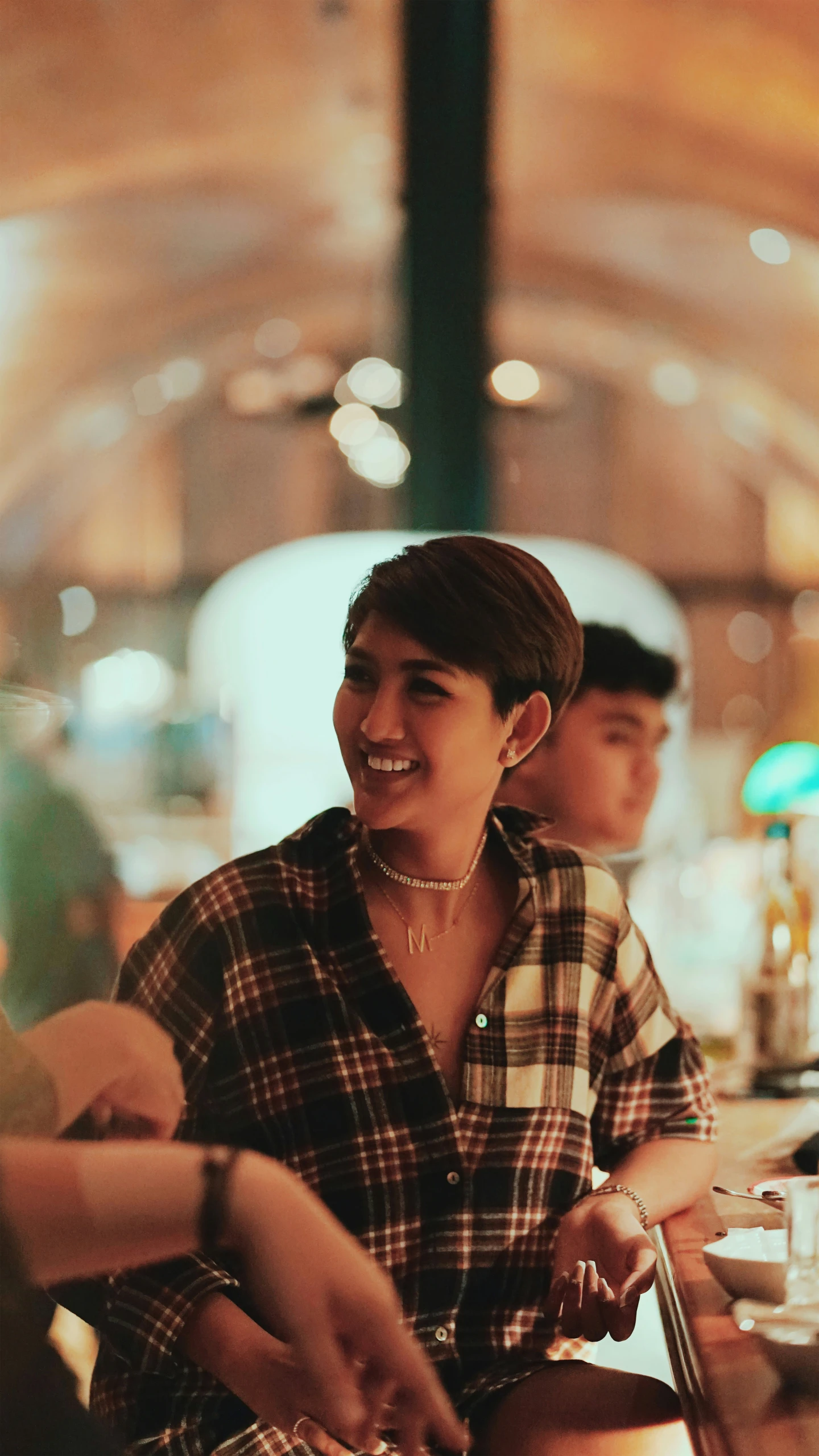 a woman sitting at a table next to other people