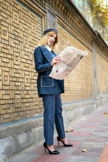 a woman is standing on the sidewalk looking at a paper