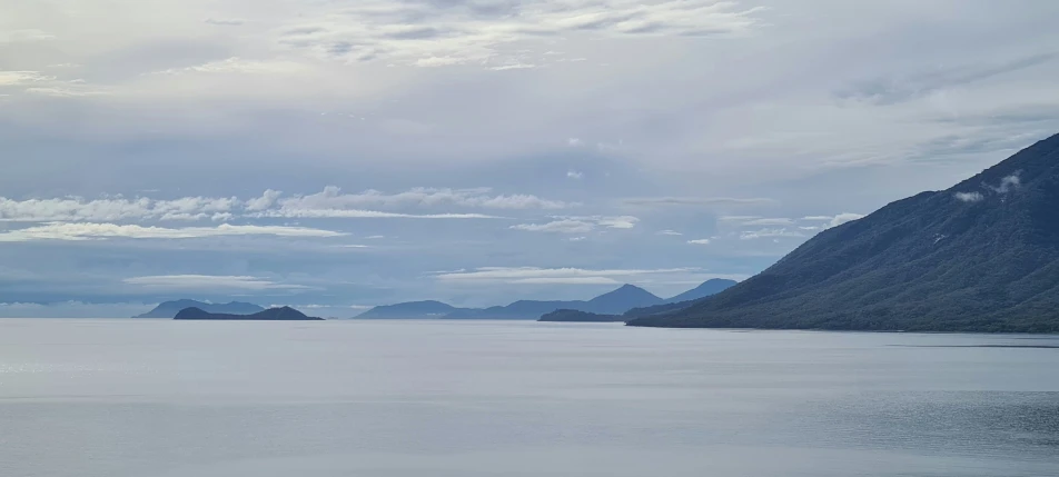 the mountains are overlooking the water and the sky