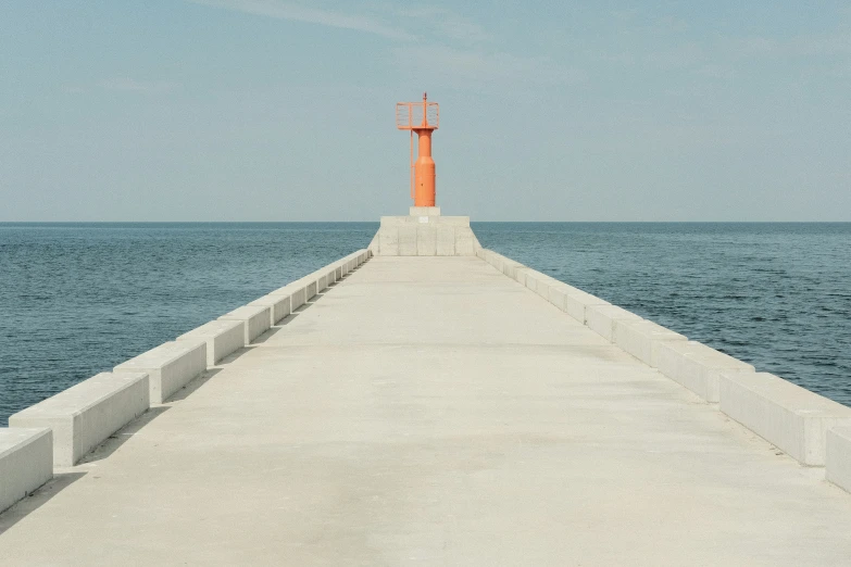 a light house at the end of a pier next to the ocean