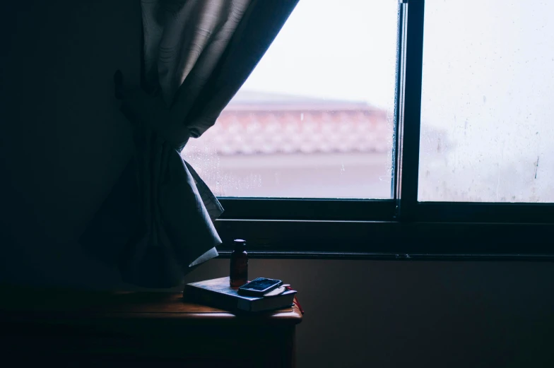 a dark room with a window and a curtain