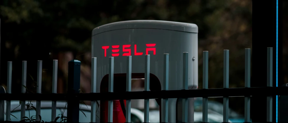 a metal fence with a red and red sign behind it