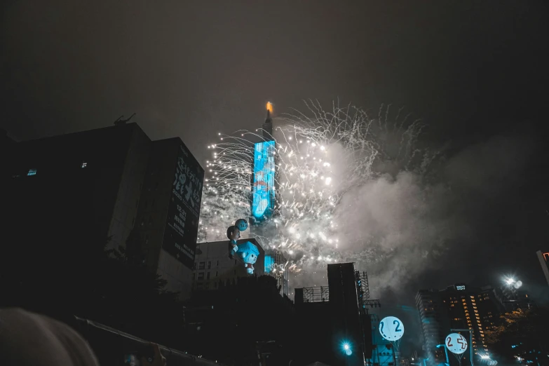 fireworks exploding in the sky above buildings and a clock tower