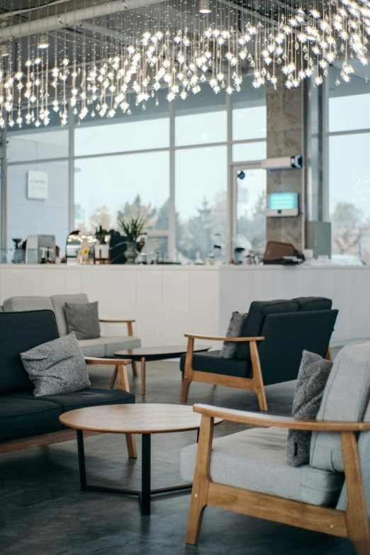 a room filled with gray furniture and a big window