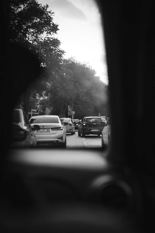 traffic at an intersection as seen through a rear view mirror