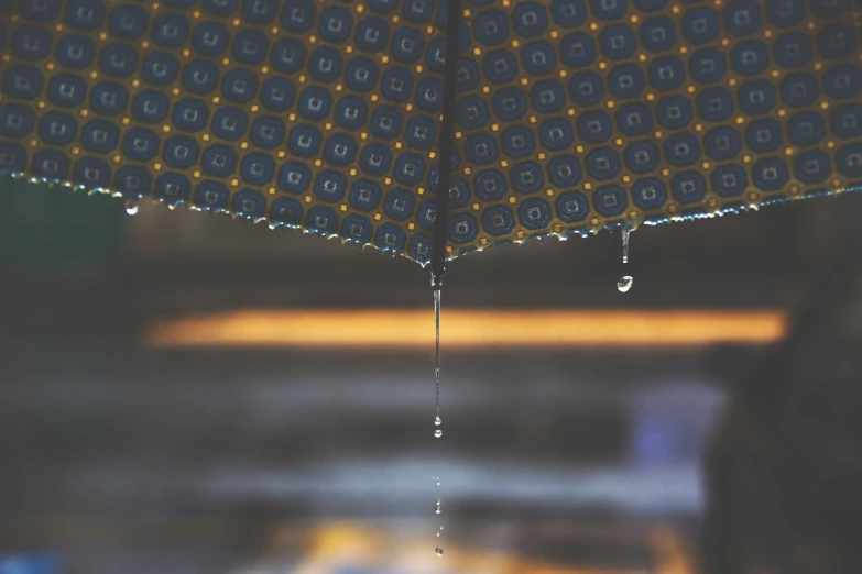 a close up of a blue umbrella with drops