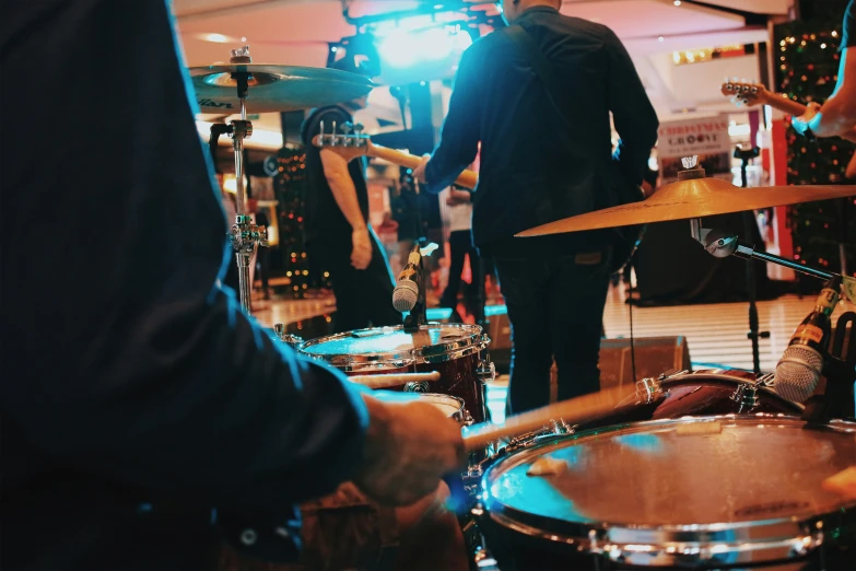 a man that is playing the drums and another person is listening