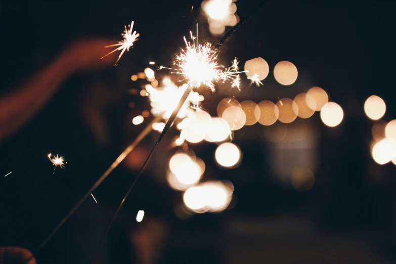 some white sparklers in the dark with blurry lights