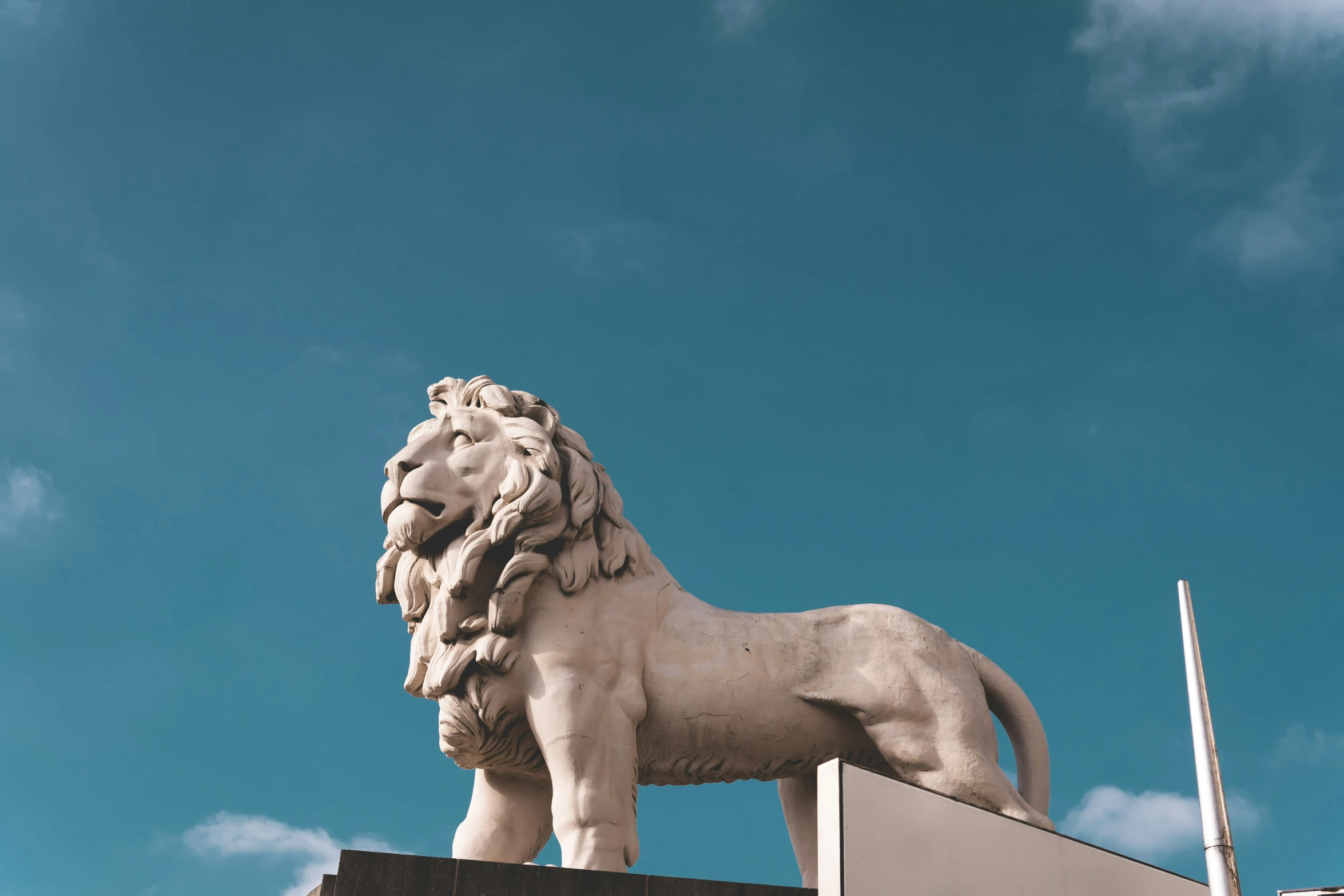 the statue is lion shaped against the blue sky