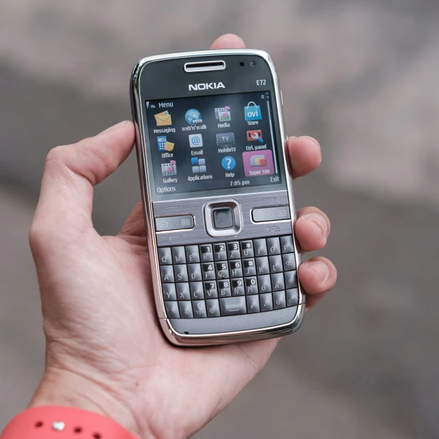 a person is holding a silver cell phone