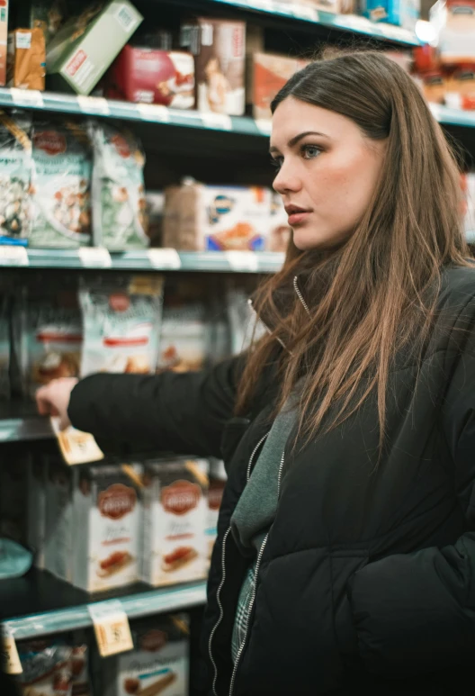 a girl standing in a store while she chooses some food