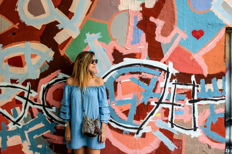 a woman is standing in front of a colorful wall