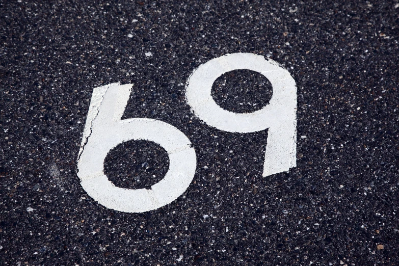 a white route 66 marker painted on asphalt