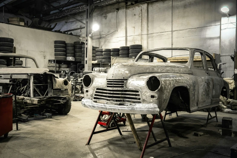 an old car being worked on in a workshop