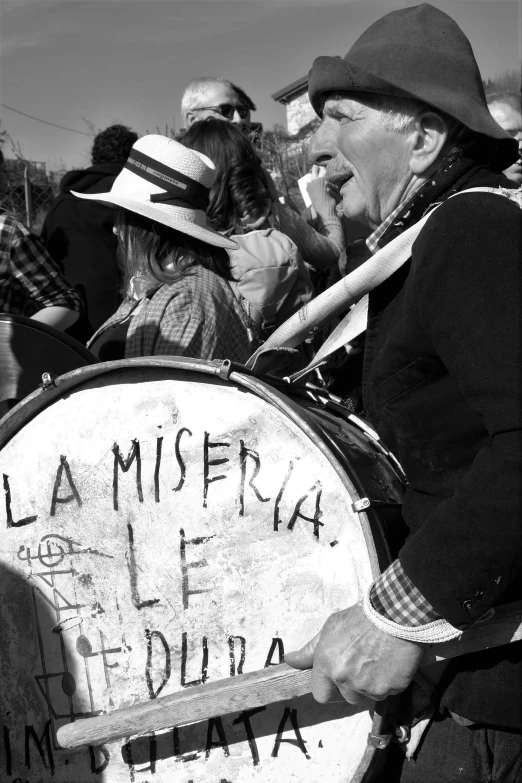 a man in a hat stands near a sign