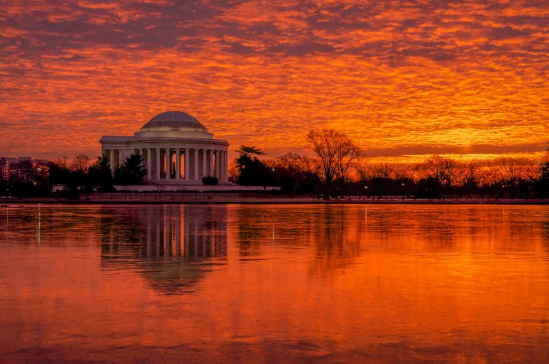 the thomas washington monument is in the distance with a sunset reflecting on it