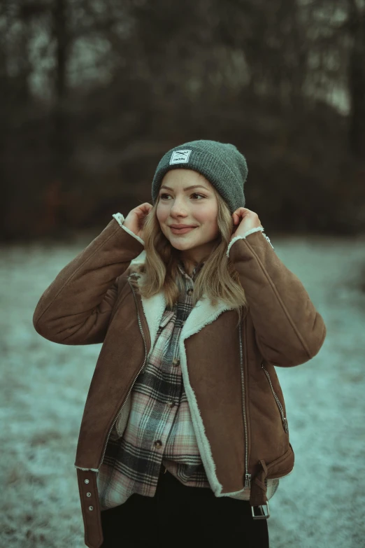 a  poses in the woods wearing a jacket