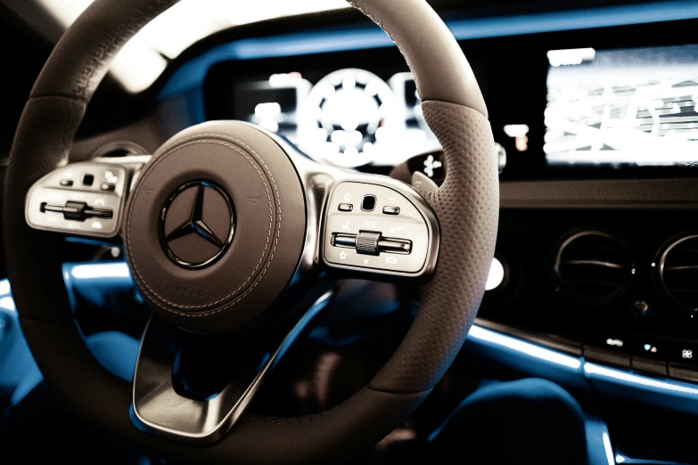 a car's steering wheel inside a vehicle, the cockpit screen is showing