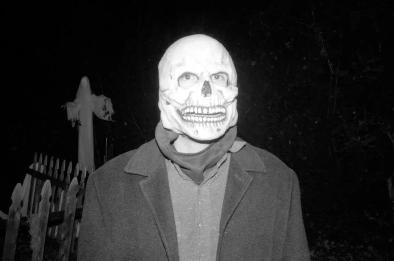 a man with a fake skull mask on posing for the camera