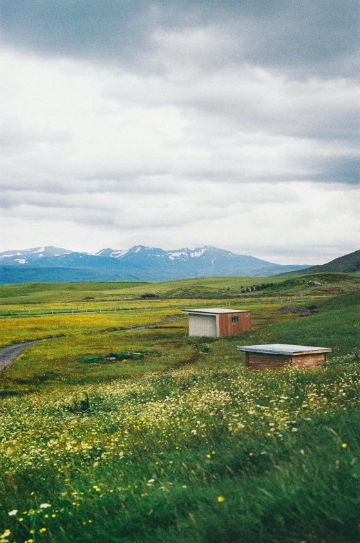 a field with benches on top of it in a mountainous region