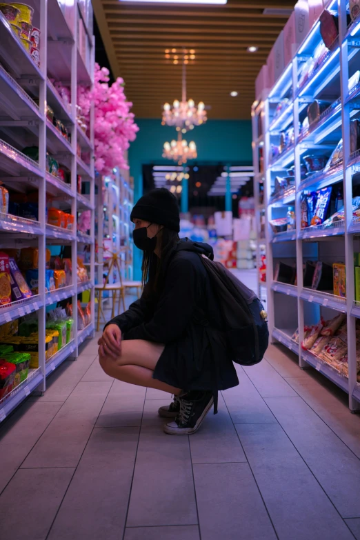 a woman crouched down in a supermarket aisle