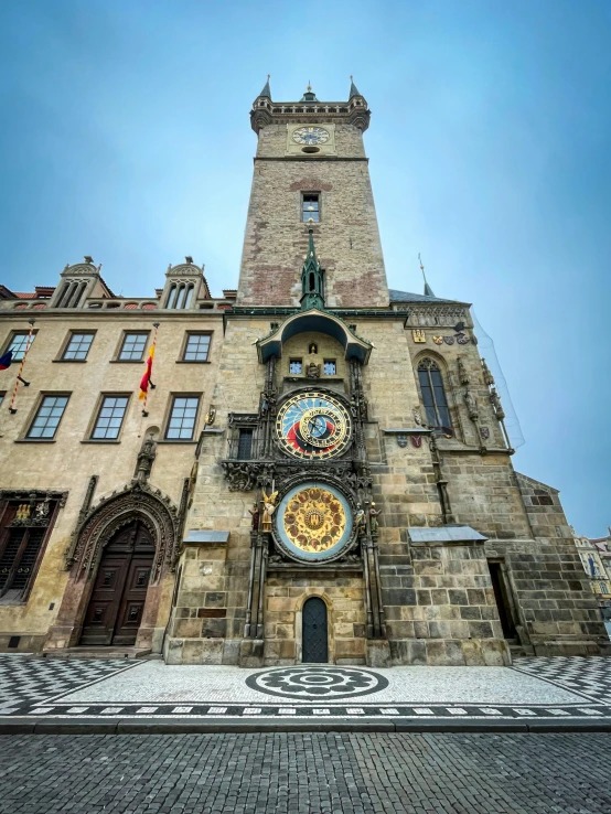 a tall building with clocks on it's face in front of it