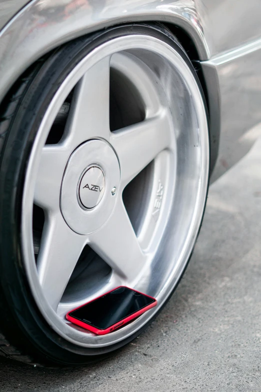 silver sports car rim and wheel spokes with red stripe