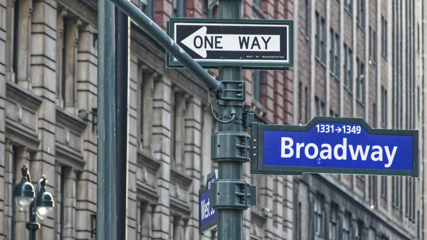 a one way street sign is on broadway