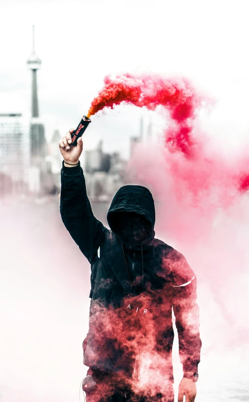 person in a hooded jacket holding a fire extinguisher