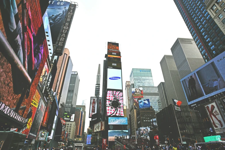 many people on a street in front of the tall buildings