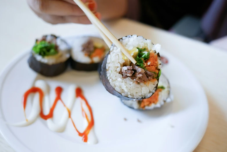 a plate with sushi and chop sticks