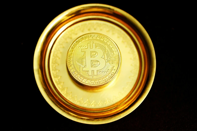 a golden coin on a black surface