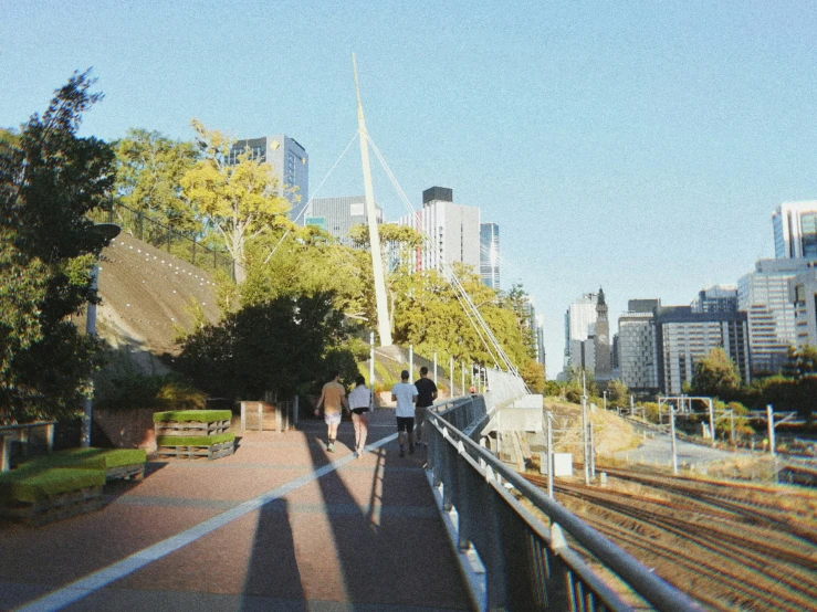 people walking over a bridge looking at the scenery