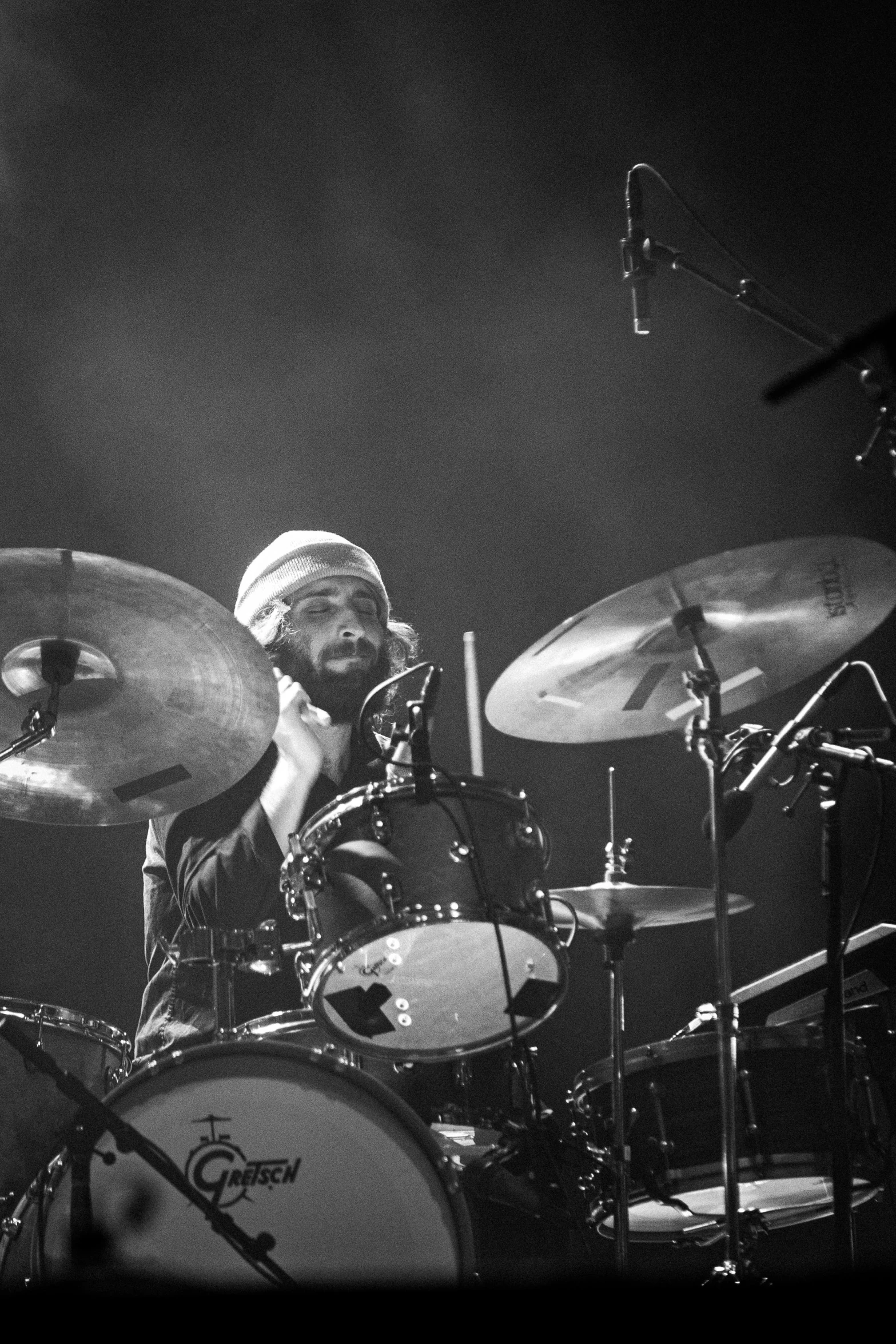 a drummer playing the drums and singing into his microphone