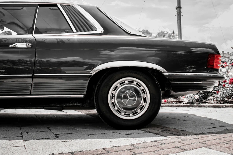 a black car that is parked on some bricks