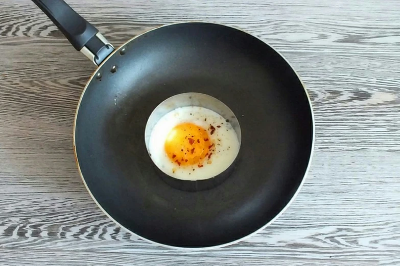 an egg frying in a wok on the table