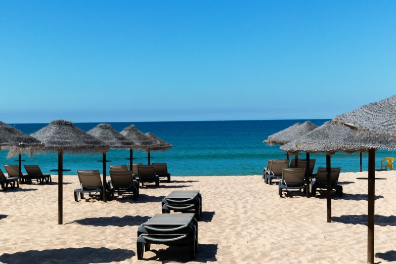 there are several chairs and umbrellas that are on the beach