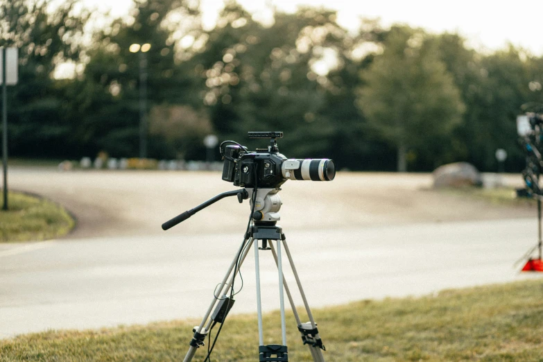 a camera is positioned on a tripod in a park