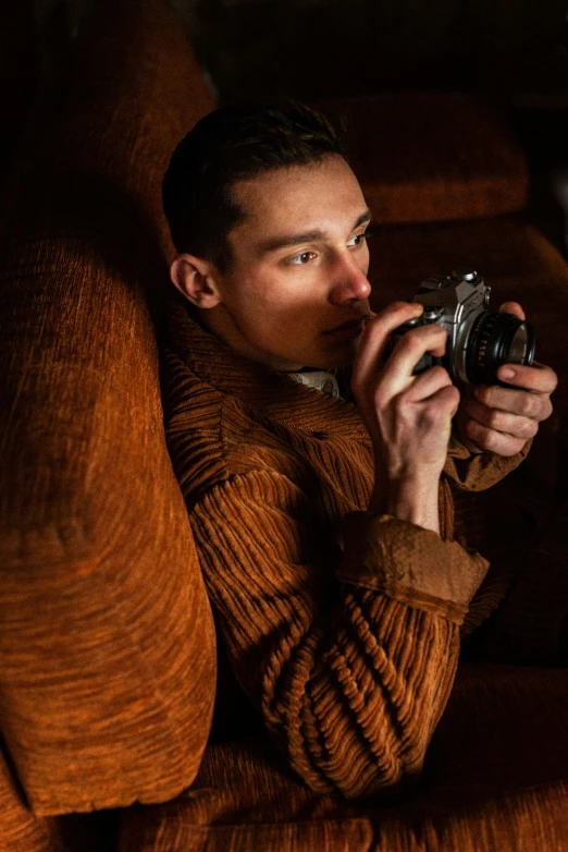 a man sitting on the couch taking a po with his camera