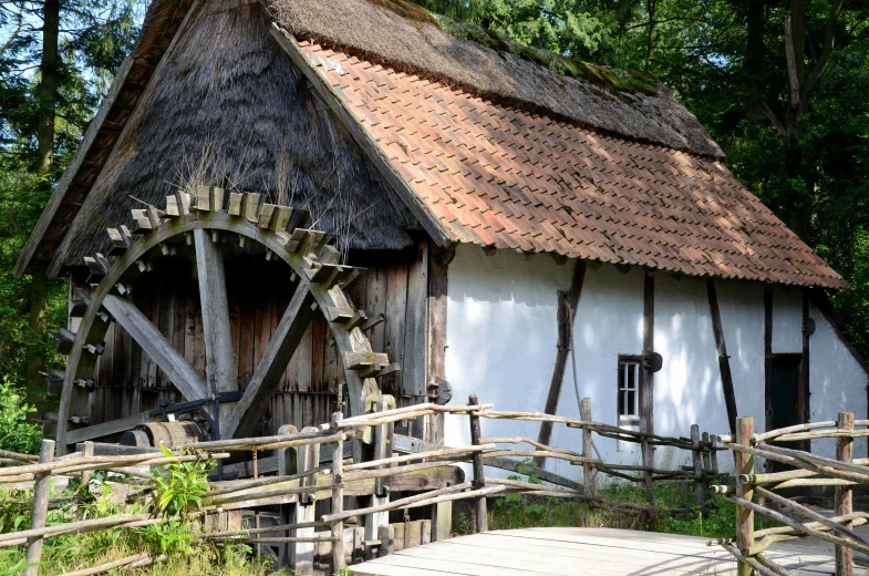 a white cottage that has a wooden fence on it