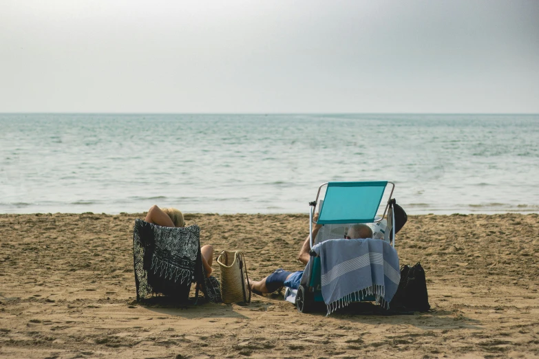 a person laying on a chair on a beach