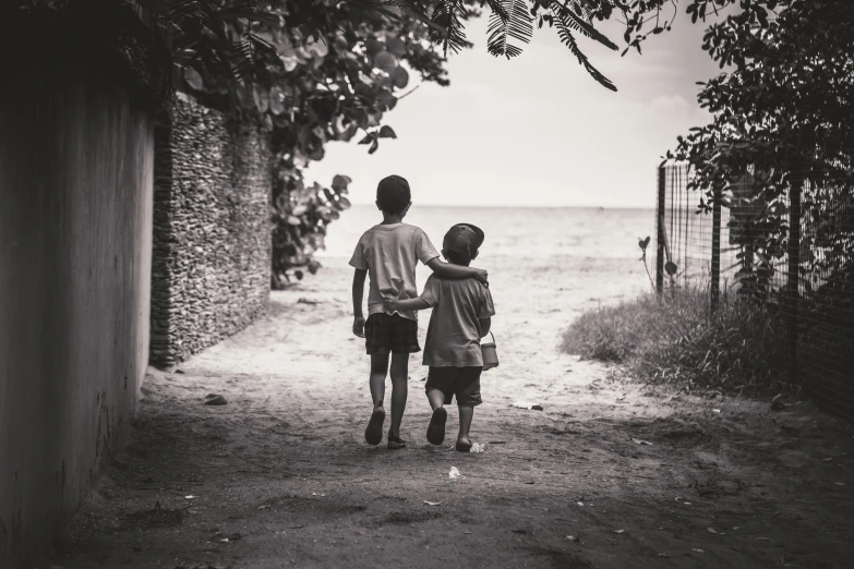 two s holding hands on a dirt path