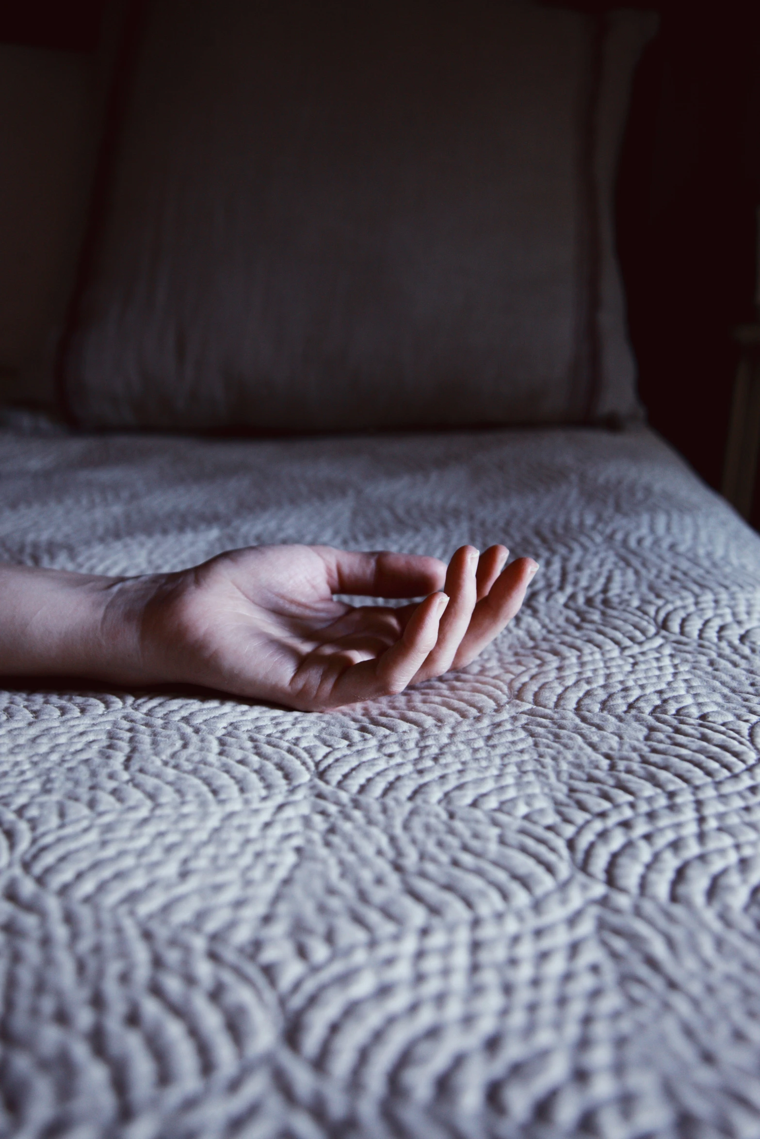 a person's hands folded out across a bed