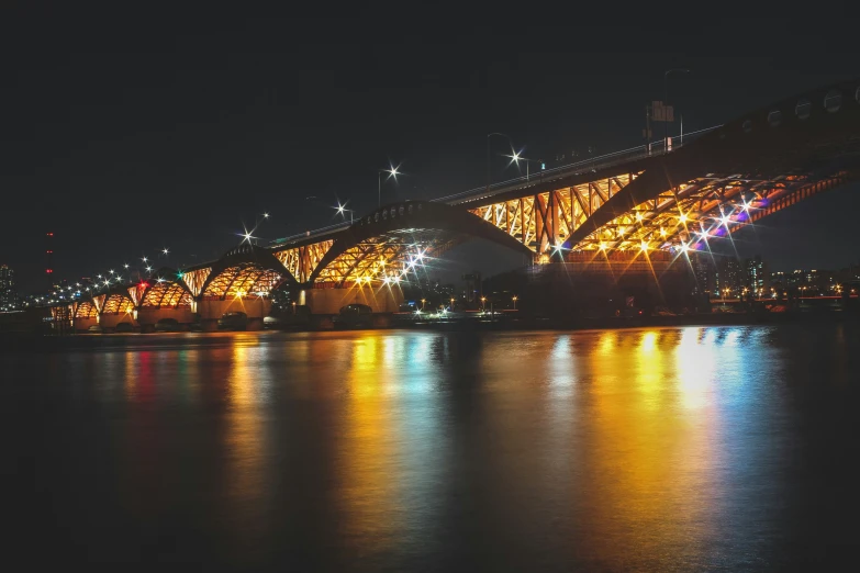 this is a bridge on the water at night