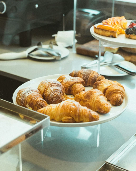 a bunch of croissants on plates on a counter
