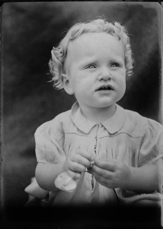 a young child standing with his hands together