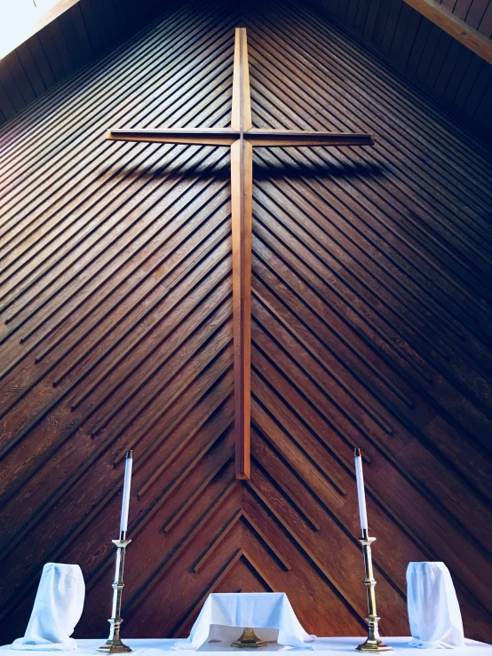 a very tall cross mounted on the side of a church