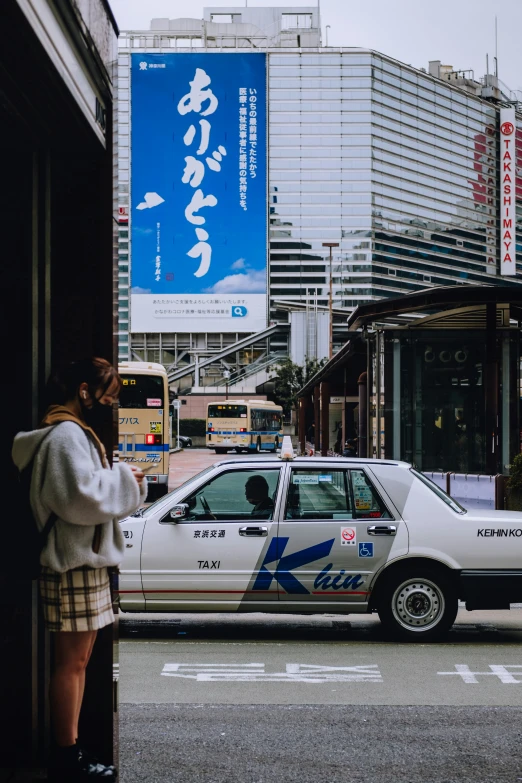 a woman standing next to a police car on the street